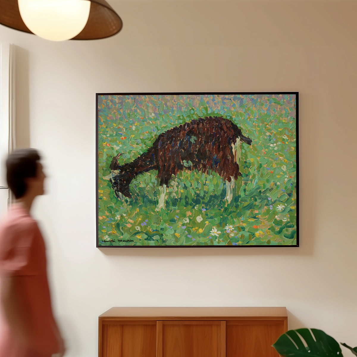 Framed art print of Chèvre dans un champ de fleurs by Henri Martin, in a slim black frame on a warm wall in a sunlit room