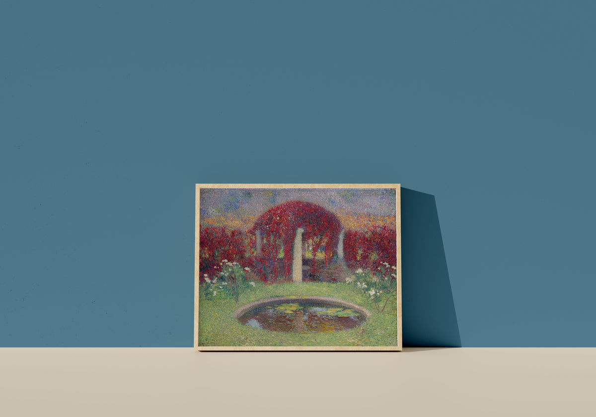 Framed art print of Le Bassin et la tonnelle by Henri Martin, in a light wood frame leaning on a blue wall