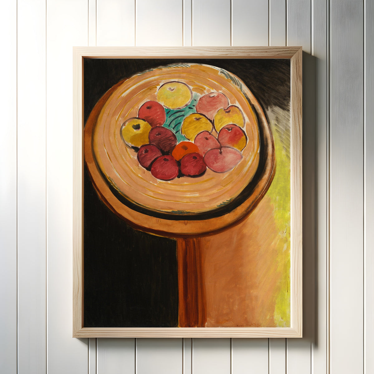 Framed art print of Apples by Henri Matisse, in a light wood frame on a white panelled wall