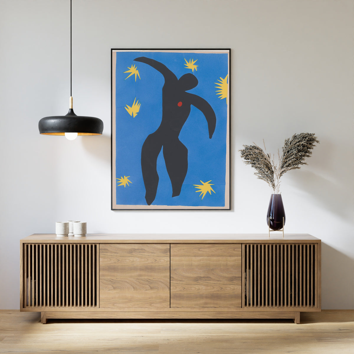 Framed art print of Icarus by Henri Matisse, above a slatted wood sideboard