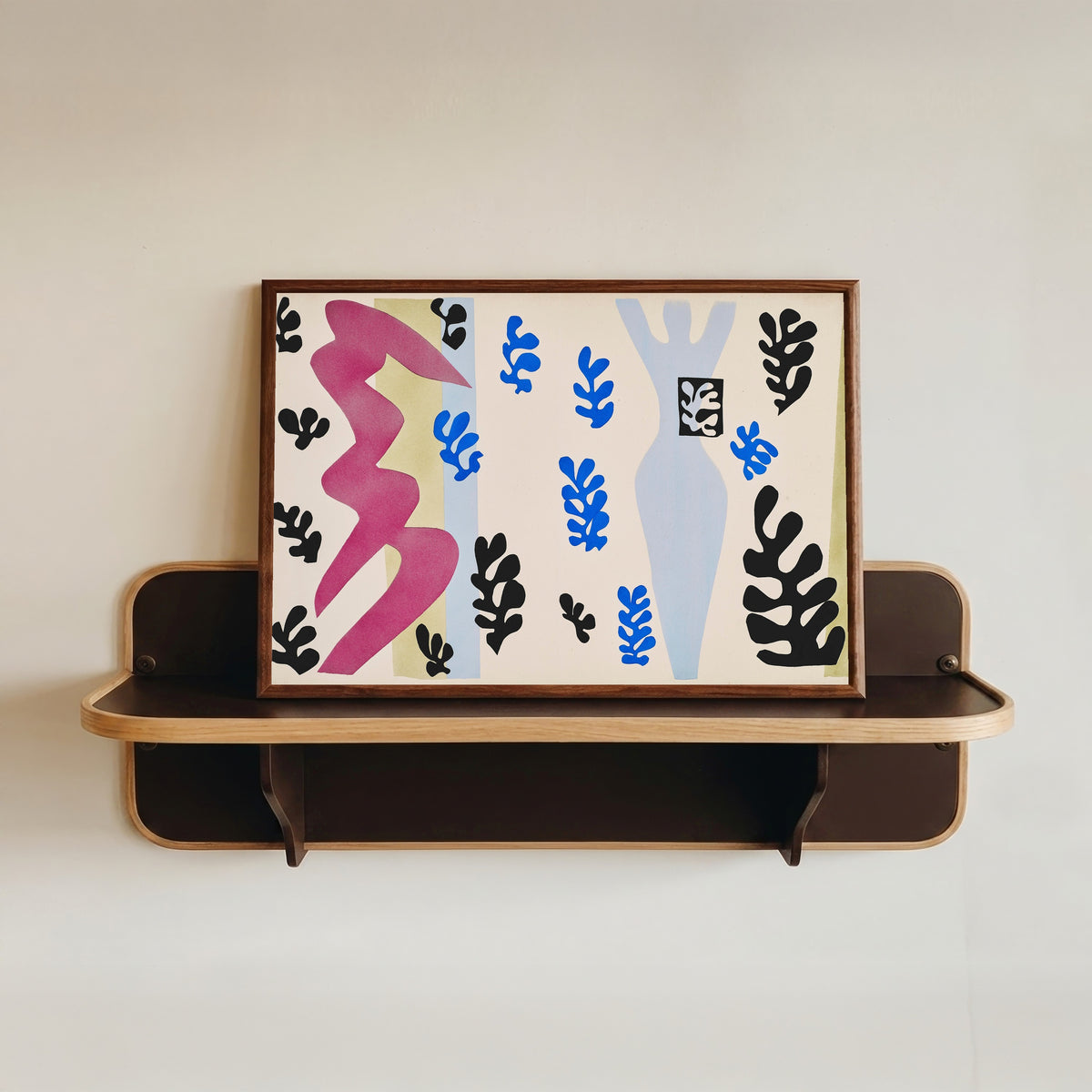 Framed art print of The Knife Thrower by Henri Matisse, in a dark wood frame resting on a wall shelf
