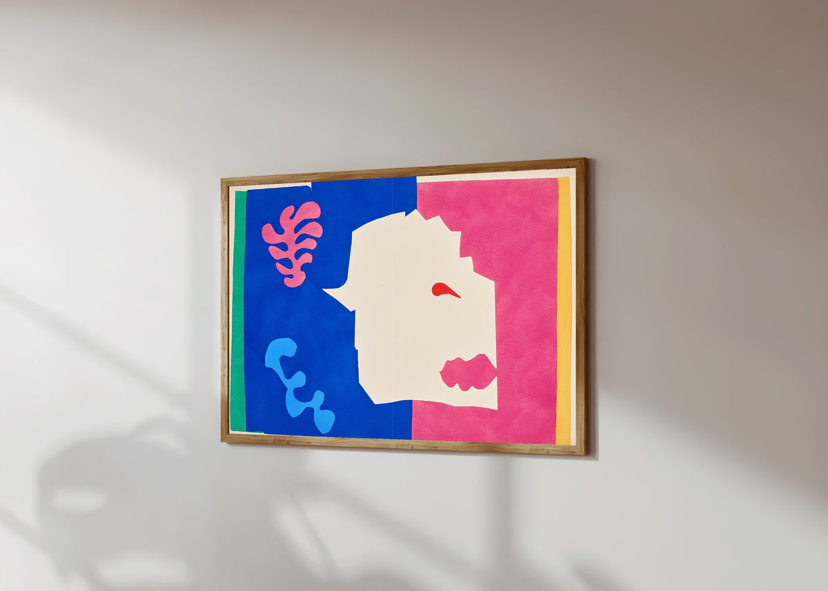 Framed art print of The Wolf by Henri Matisse, in a light wood frame on a sunlit white wall, seen at a slight angle