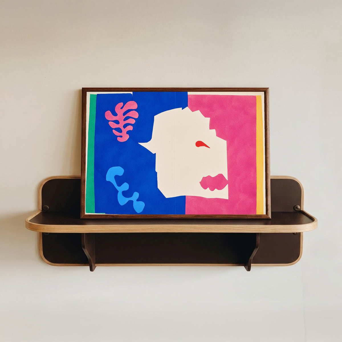 Framed art print of The Wolf by Henri Matisse, in a dark wood frame resting on a wall shelf