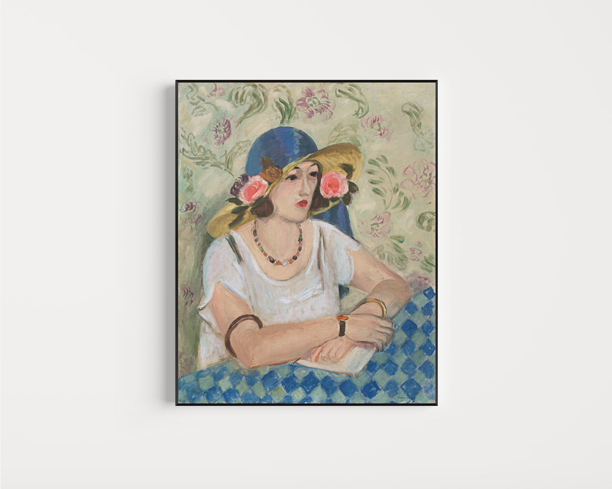 Framed art print of Woman with a Flowered Hat by Henri Matisse, in a slim black frame on a plain white wall