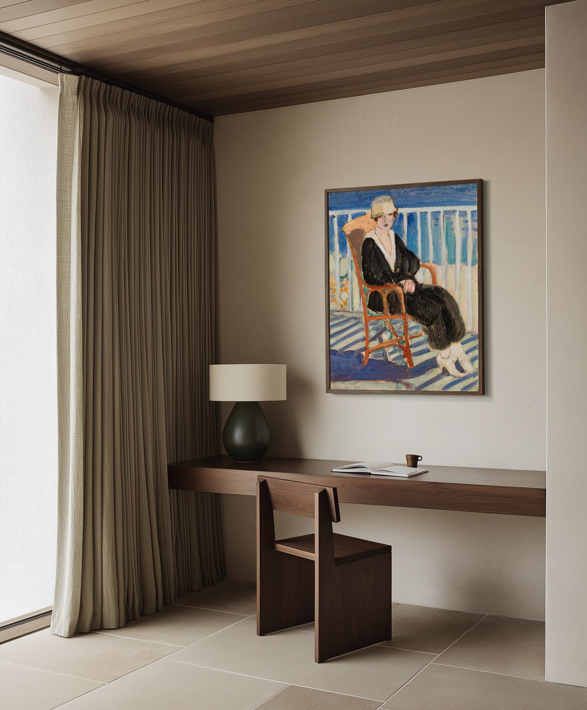 Framed art print of Young Girl on a Balcony over the Ocean by Henri Matisse, in a dark wood frame on a plaster wall above a walnut desk
