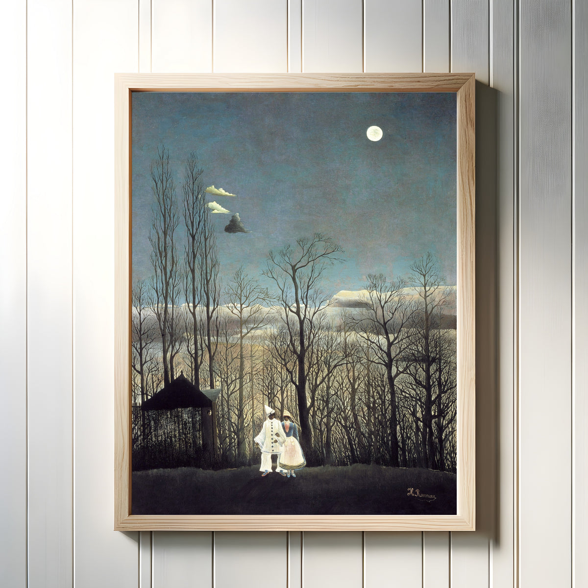 Framed art print of Carnival Evening by Henri Rousseau, in a light wood frame on a white panelled wall