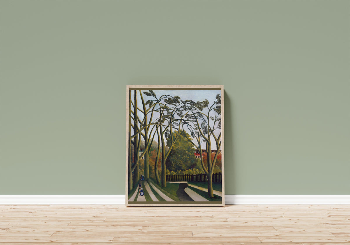 Framed art print of The Banks of the Bièvre near Bicêtre by Henri Rousseau, in a light wood frame leaning on a sage green wall above a wooden floor