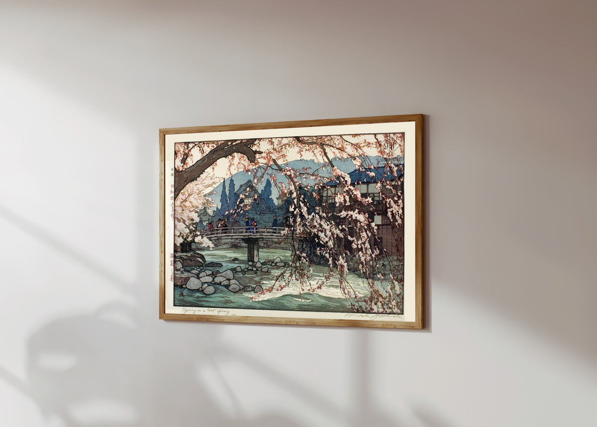 Framed art print of Spring Spa by Hiroshi Yoshida, in a light wood frame on a sunlit white wall, seen at a slight angle