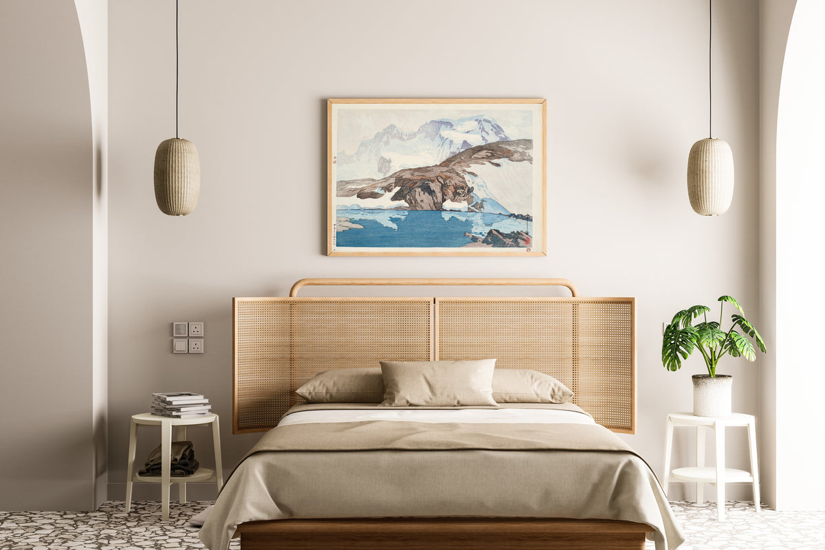 Framed art print of Breithorn by Hiroshi Yoshida, above a cane-headboard bed
