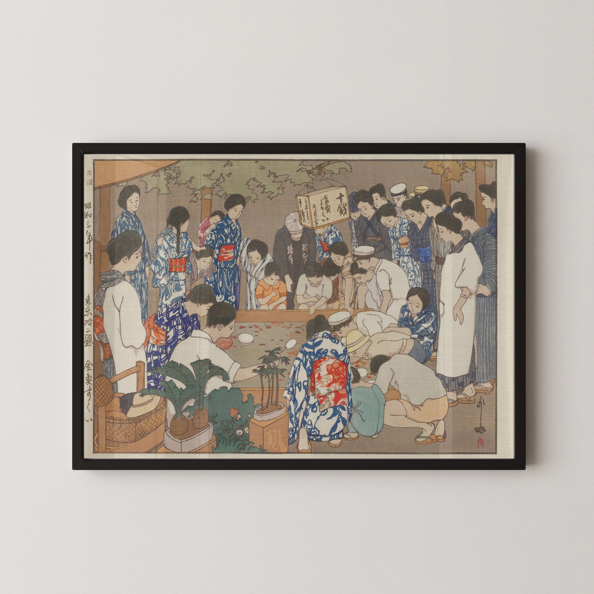 Framed art print of Dipping for Goldfish by Hiroshi Yoshida, in a black frame on a pale wall