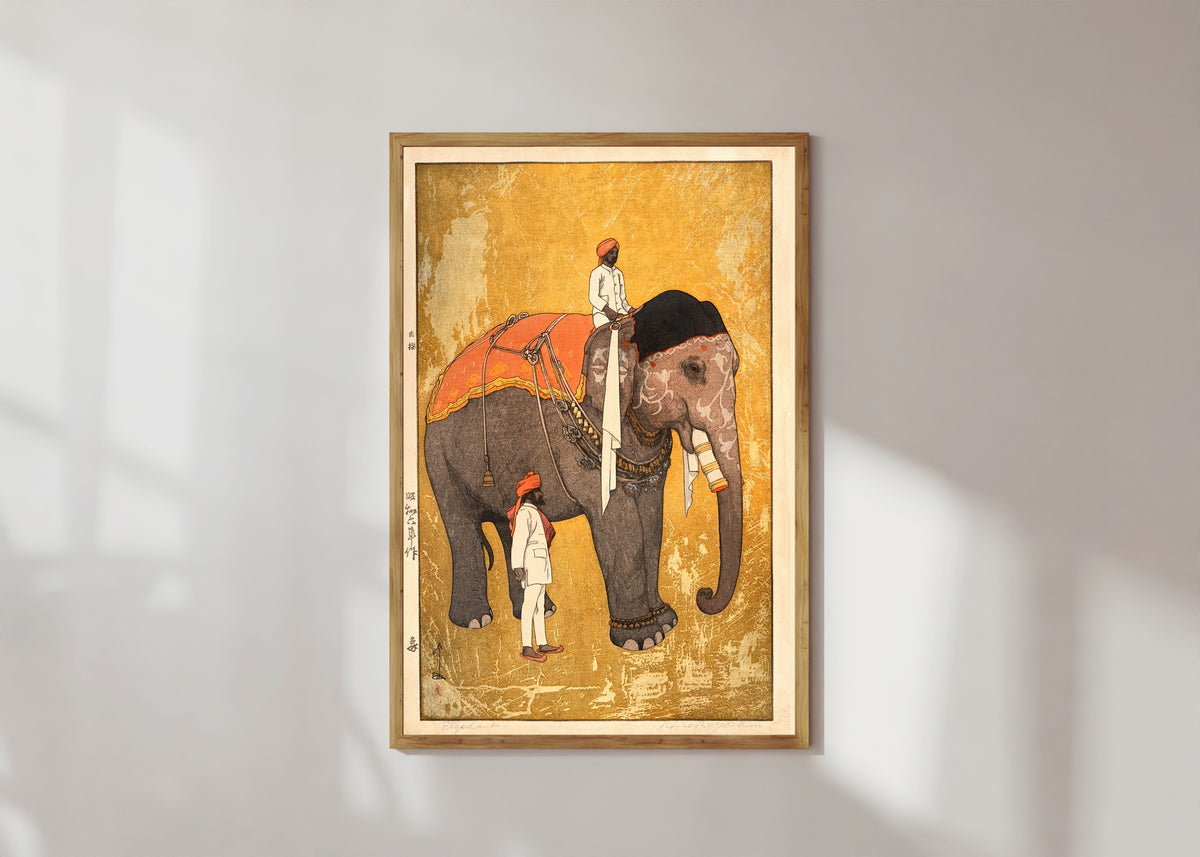 Framed art print of Elephant and Rider by Hiroshi Yoshida, in a light wood frame on a sunlit white wall