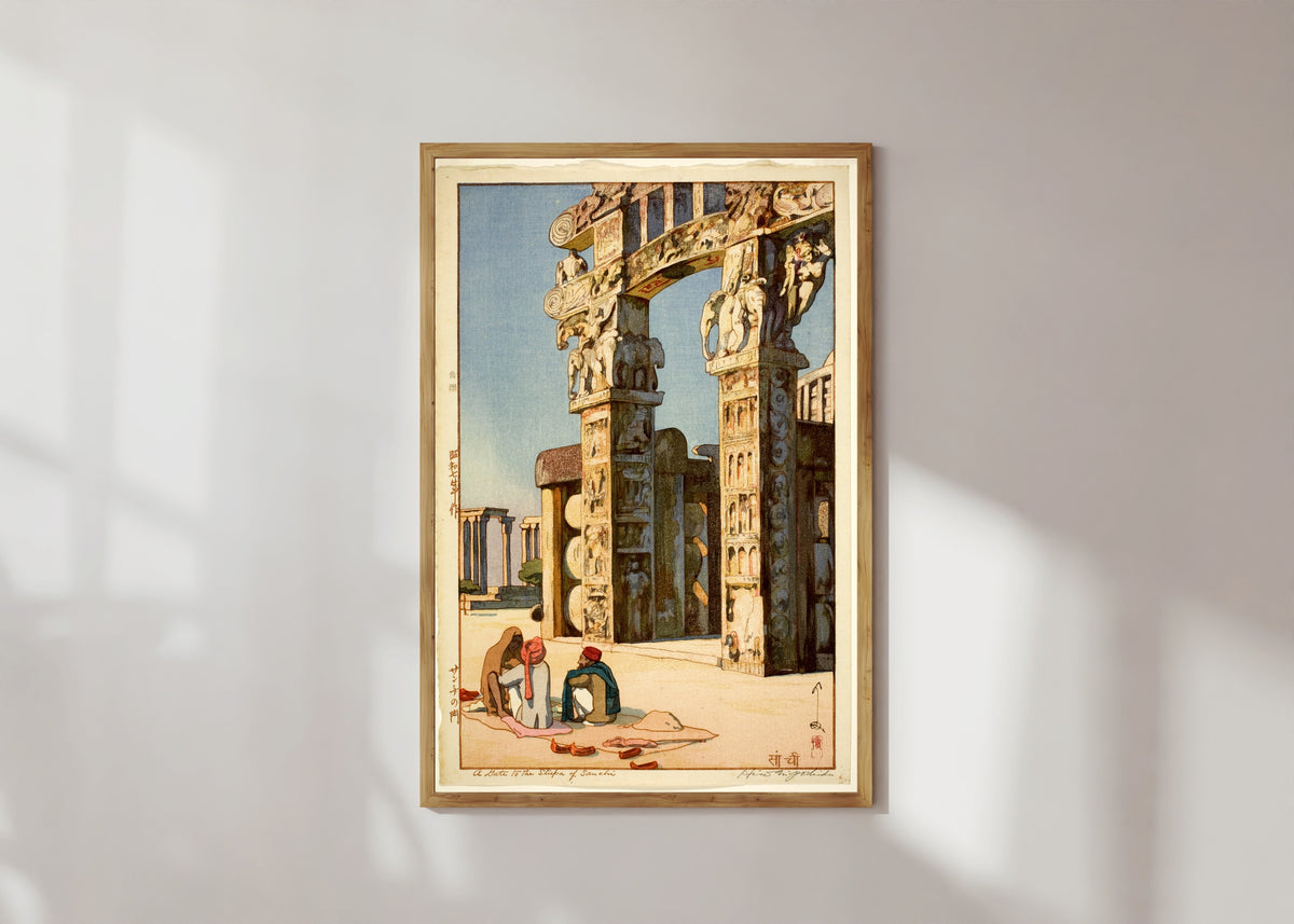 Framed art print of Gate to the Stupa at Sanchi, India by Hiroshi Yoshida, in a light wood frame on a sunlit white wall