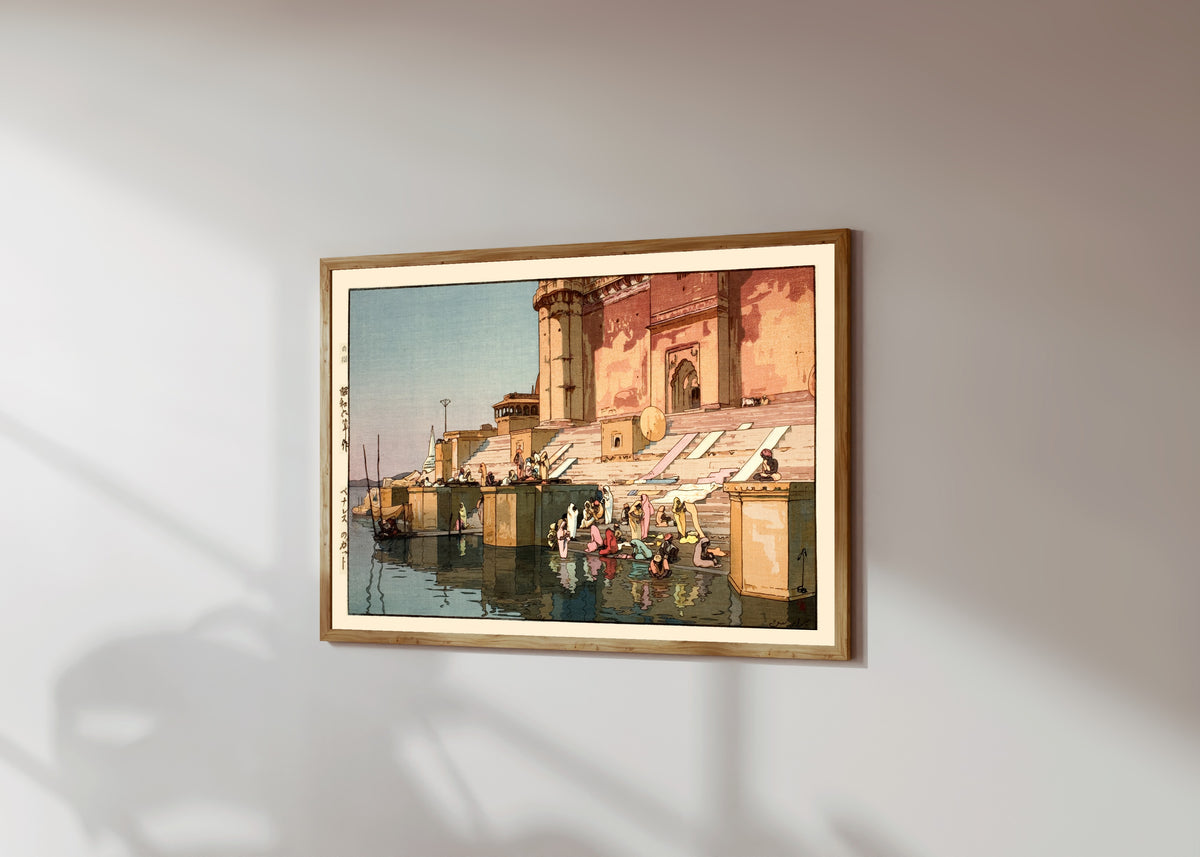 Framed art print of Ghat in Benares, India by Hiroshi Yoshida, in a light wood frame on a sunlit white wall, seen at a slight angle