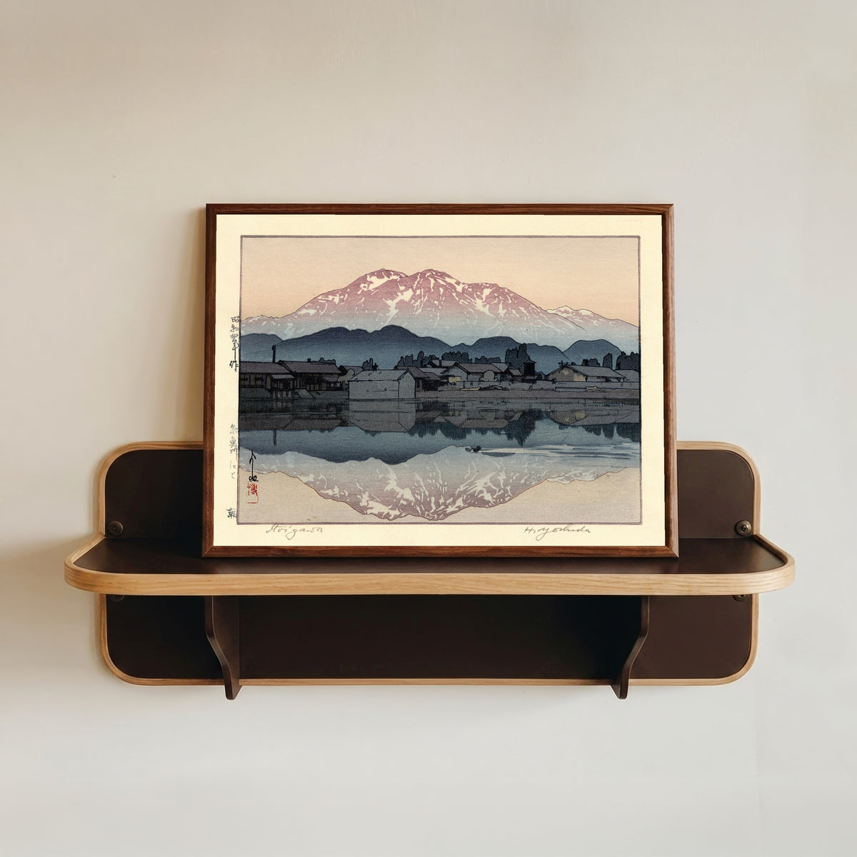 Framed art print of Itoigawa Morning by Hiroshi Yoshida, in a dark wood frame resting on a wall shelf
