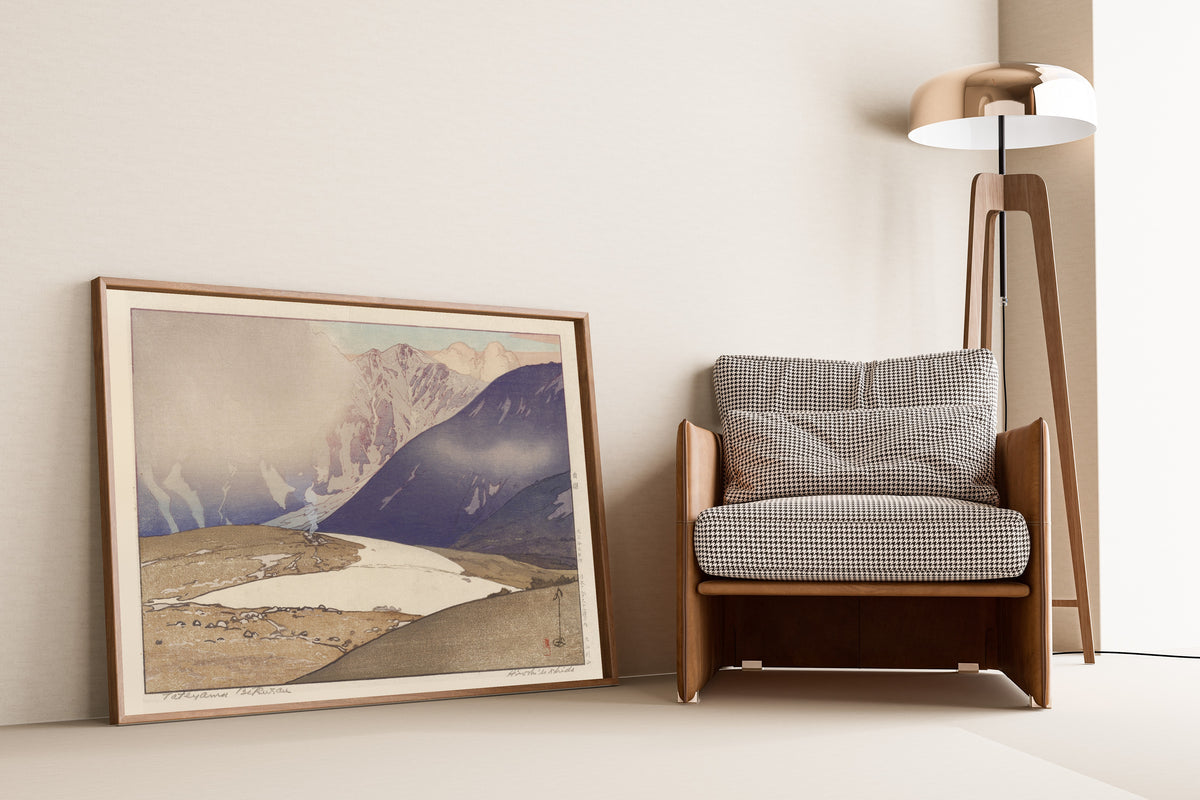 Framed art print of Tateyama Betsuzan by Hiroshi Yoshida, leaning against a wall beside an armchair and a floor lamp