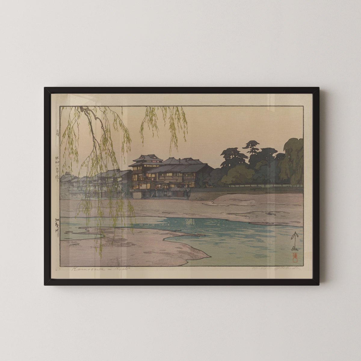 Framed art print of The Kamo River by Hiroshi Yoshida, in a black frame on a pale wall