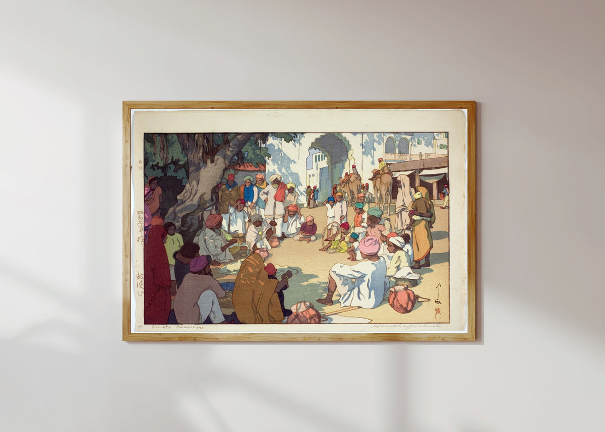 Framed art print of Snake Charmers by Hiroshi Yoshida, in a light wood frame on a sunlit white wall