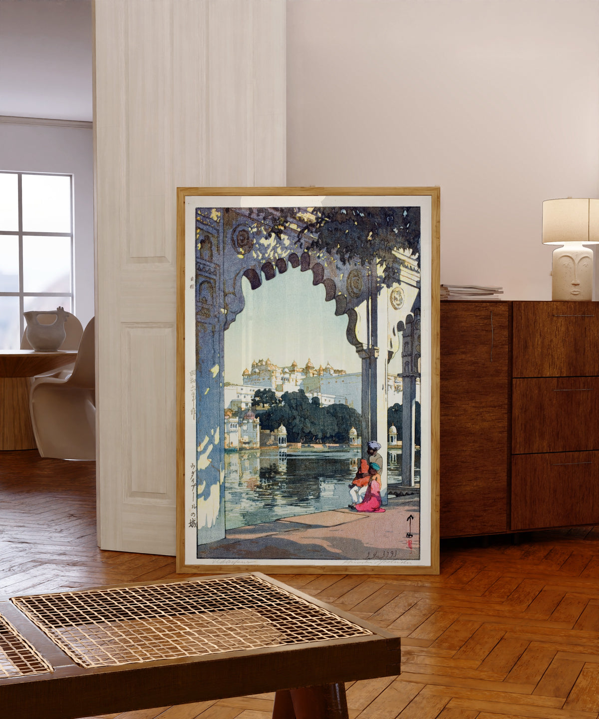 Framed art print of Udaipur Castle, India by Hiroshi Yoshida, in a light wood frame leaning in a warm room with a parquet floor