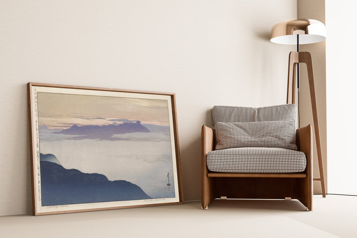 Framed art print of Yatsugatake after Rain by Hiroshi Yoshida, leaning against a wall beside an armchair and a floor lamp
