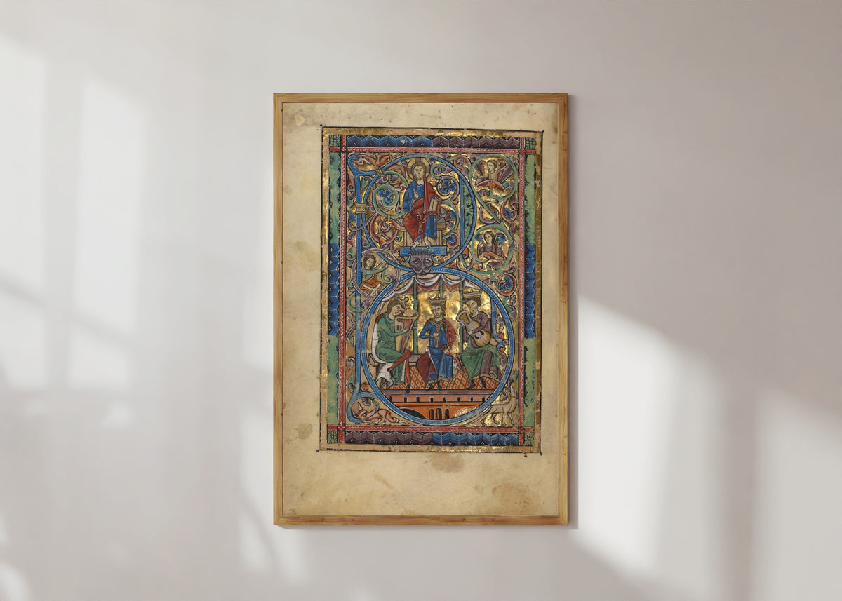 Framed art print of Initial B: Christ in Majesty and David with Musicians, in a light wood frame on a sunlit white wall