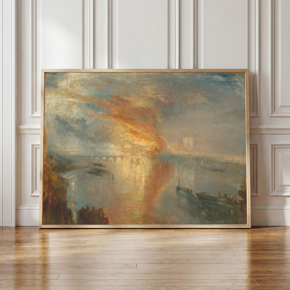 Framed art print of The Burning of the Houses of Lords and Commons, 16 October… by J.M.W. Turner, in a light wood frame leaning against a panelled white wall