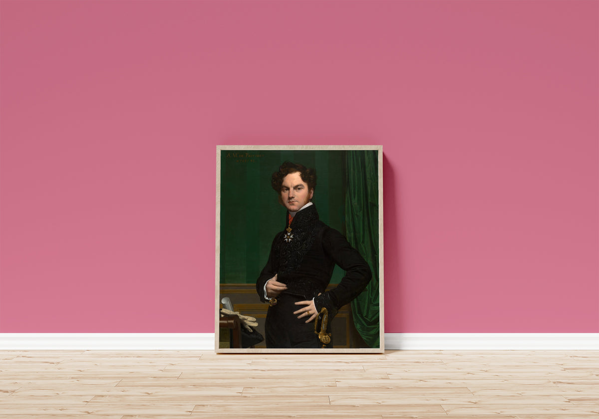 Framed art print of Amédée-David, the Comte de Pastoret by Jean-Auguste-Dominique Ingres, in a light wood frame leaning on a pink wall above a wooden floor
