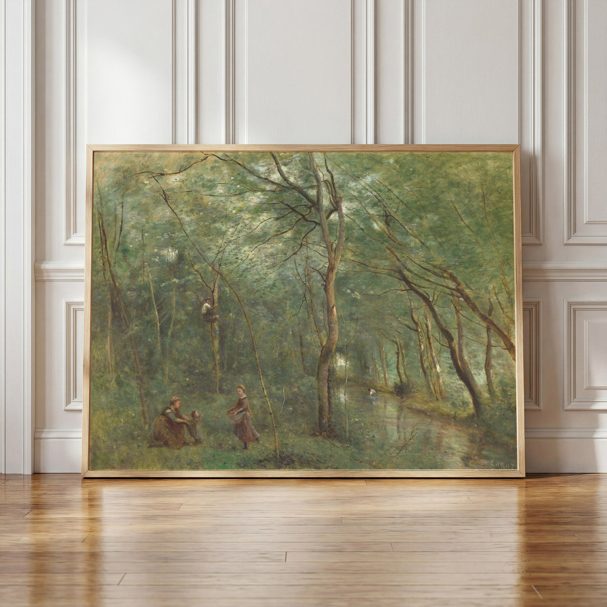 Framed art print of The Eel Gatherers by Jean-Baptiste-Camille Corot, in a light wood frame leaning against a panelled white wall
