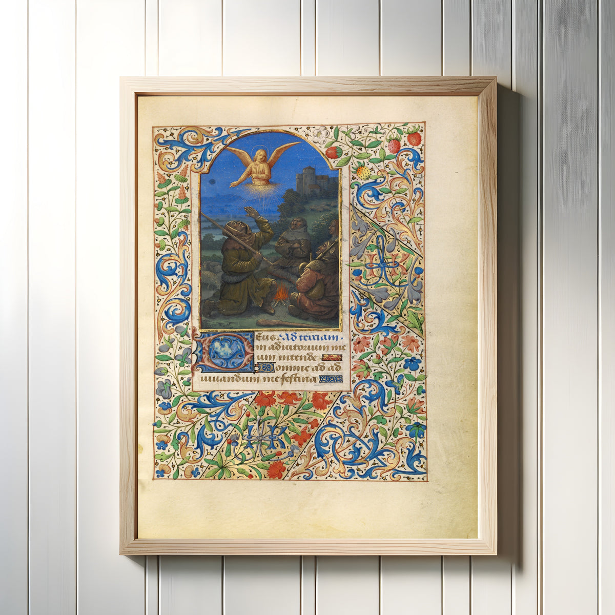 Framed art print of The Annunciation to the Shepherds by Jean Bourdichon, in a light wood frame on a white panelled wall