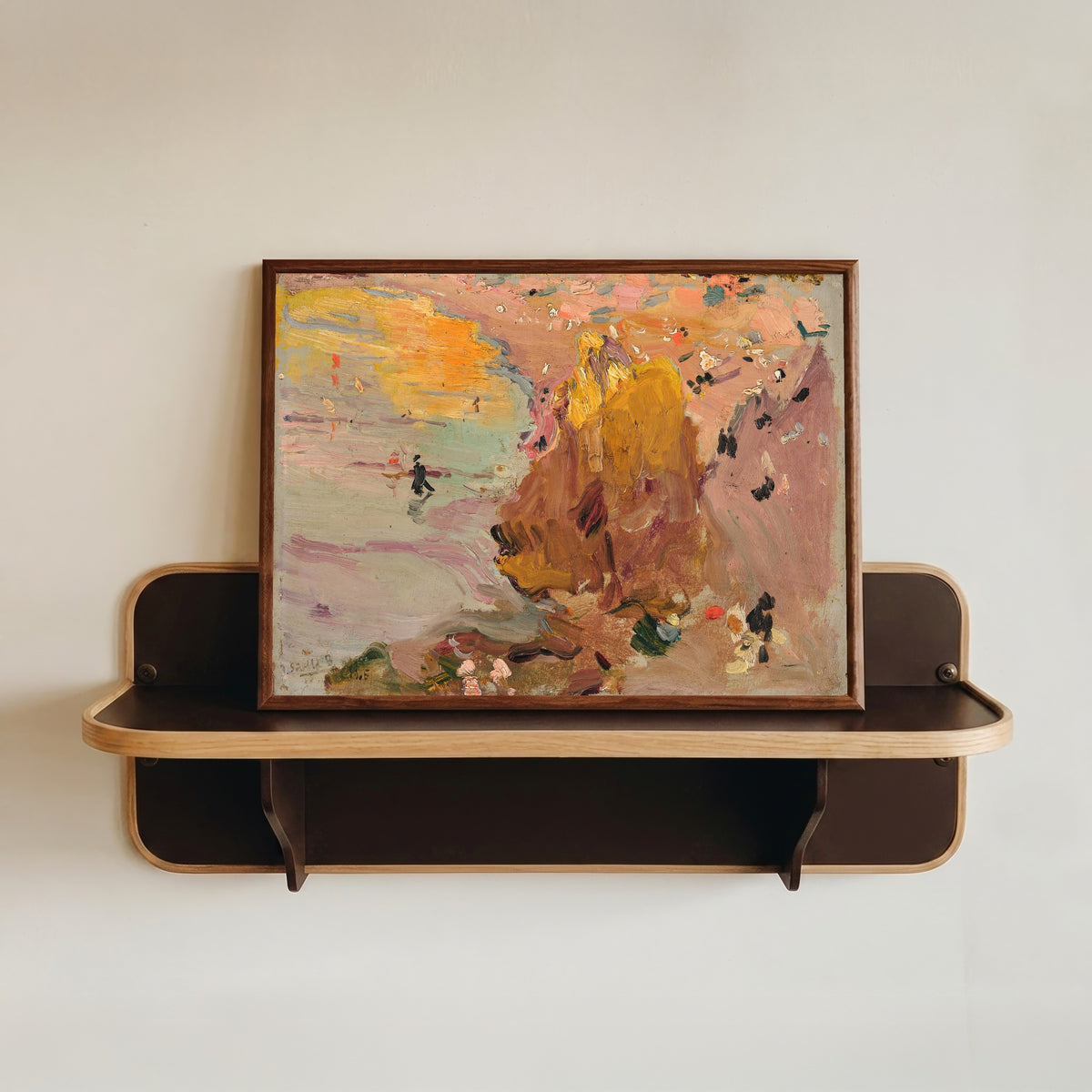 Framed art print of Beach of Biarritz by Joaquín Sorolla, in a dark wood frame resting on a wall shelf