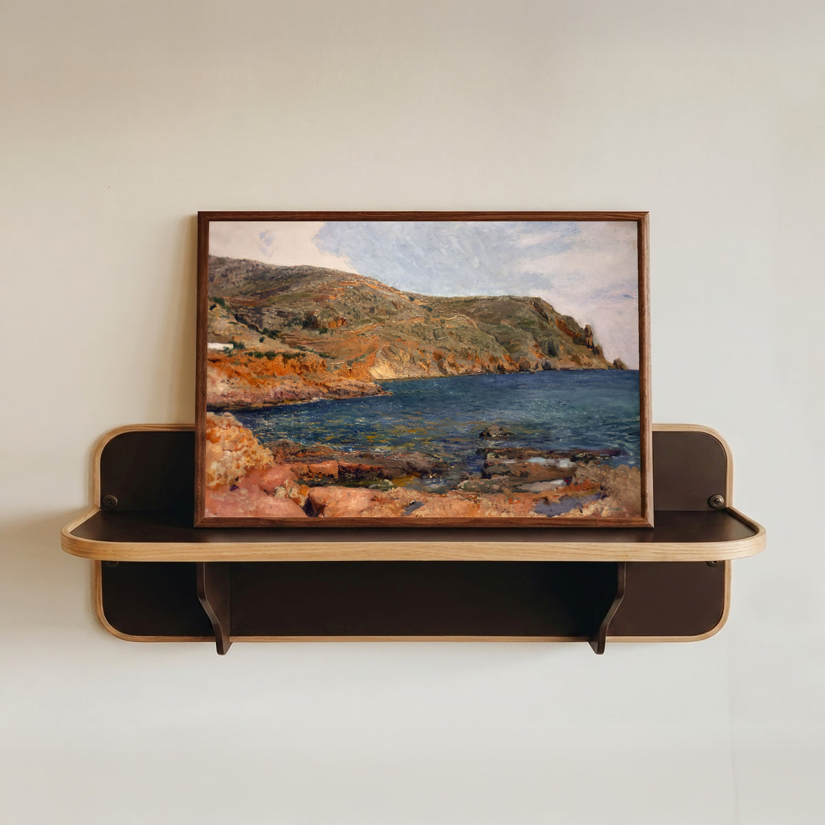 Framed art print of Cape San Antonio, Jávea by Joaquín Sorolla, in a dark wood frame resting on a wall shelf