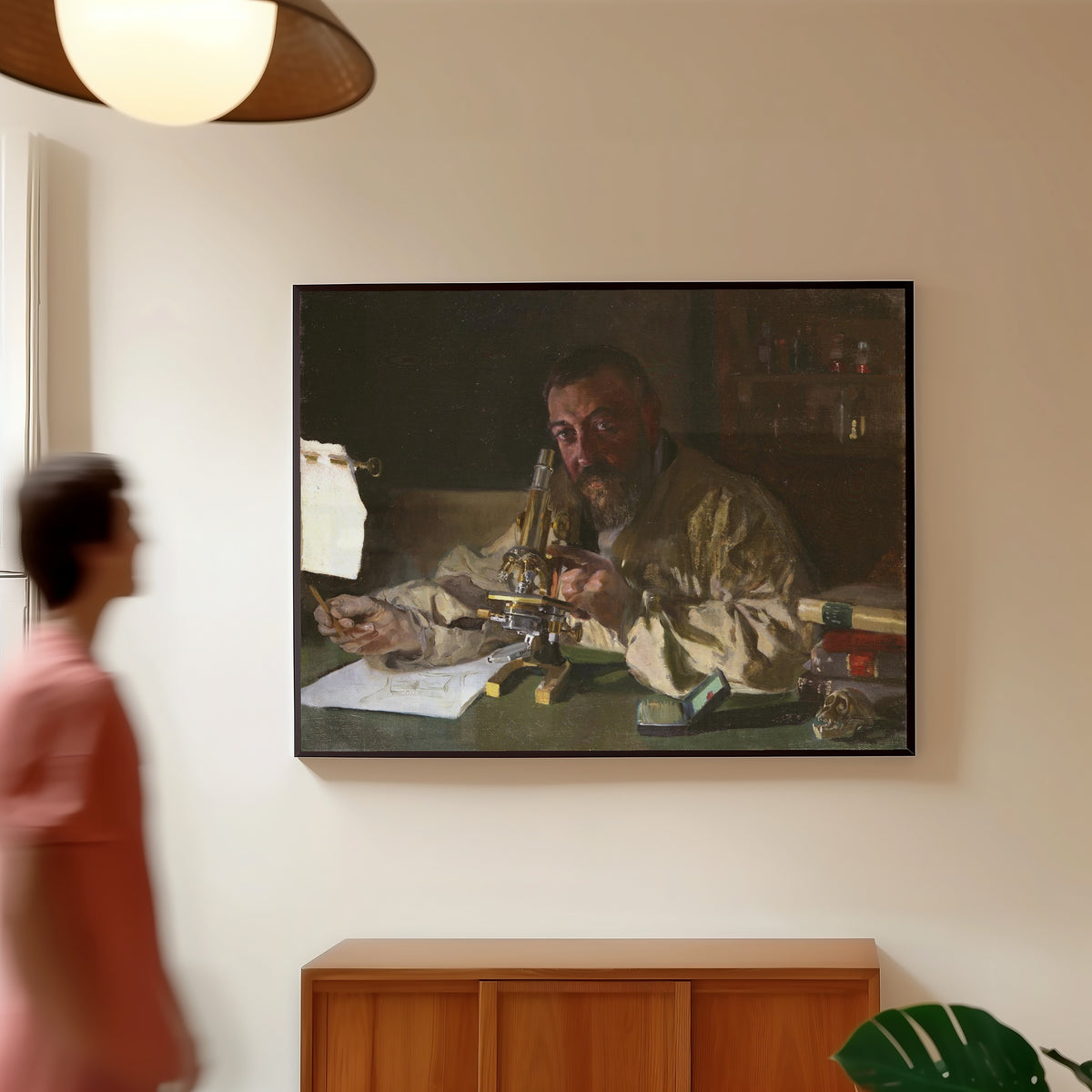 Framed art print of Dr. Simarro at the Microscope by Joaquín Sorolla, in a slim black frame on a warm wall in a sunlit room