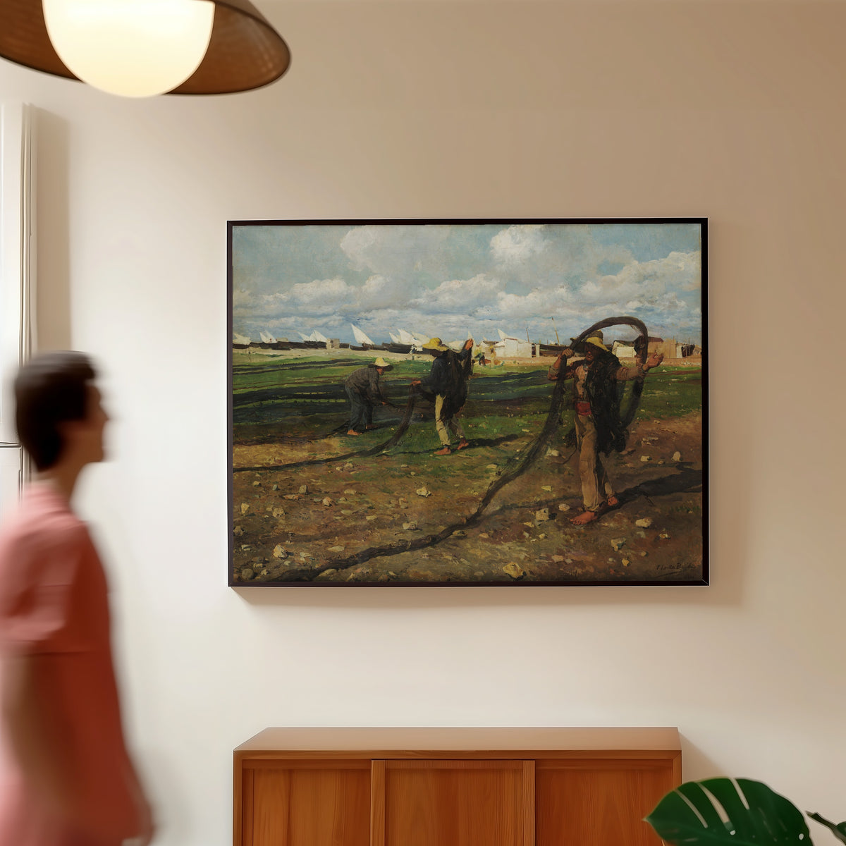 Framed art print of Fishermen with their Nets by Joaquín Sorolla, in a slim black frame on a warm wall in a sunlit room
