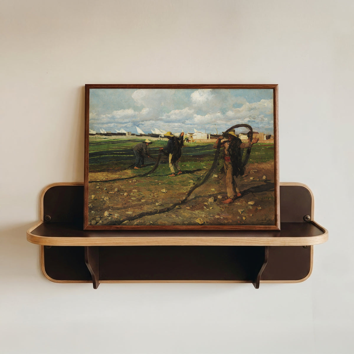 Framed art print of Fishermen with their Nets by Joaquín Sorolla, in a dark wood frame resting on a wall shelf