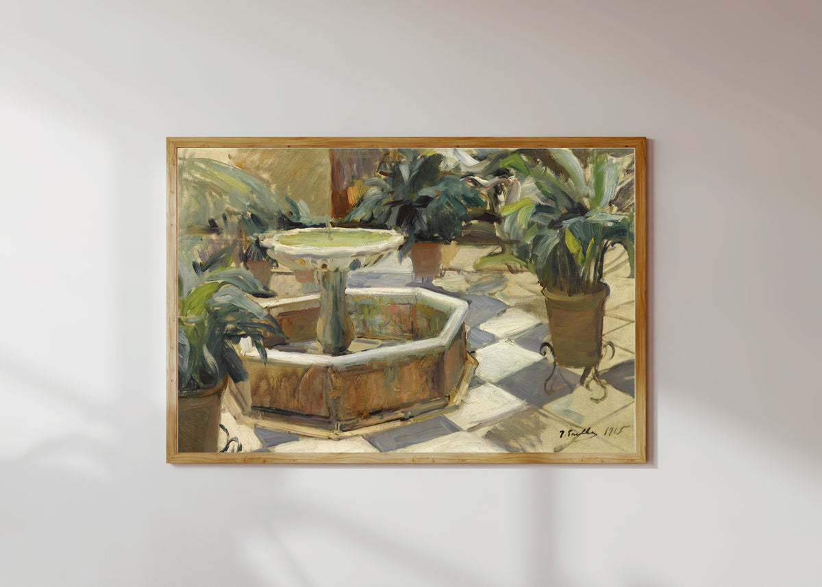 Framed art print of Fountain in a Sevillian Courtyard by Joaquín Sorolla, in a light wood frame on a sunlit white wall