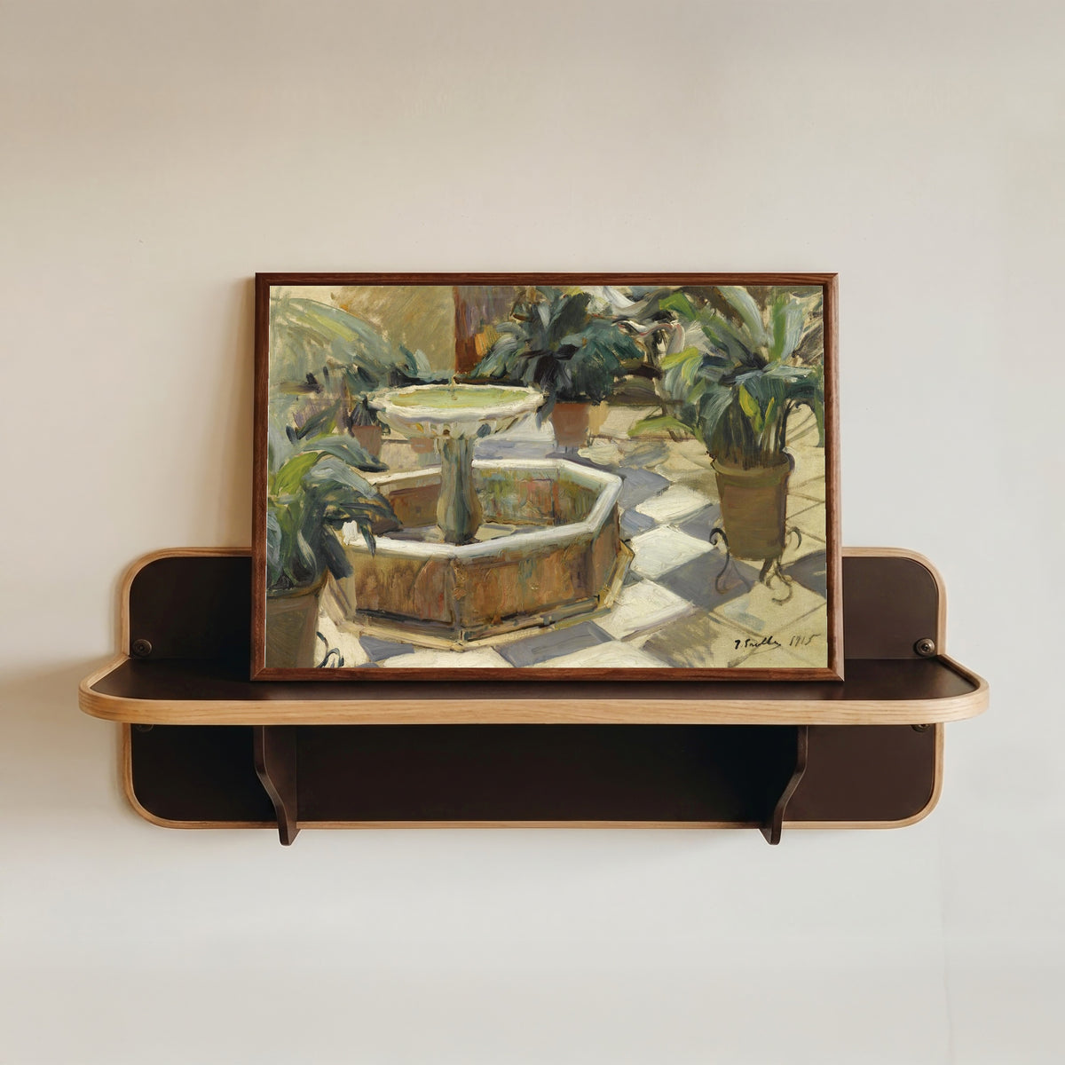 Framed art print of Fountain in a Sevillian Courtyard by Joaquín Sorolla, in a dark wood frame resting on a wall shelf