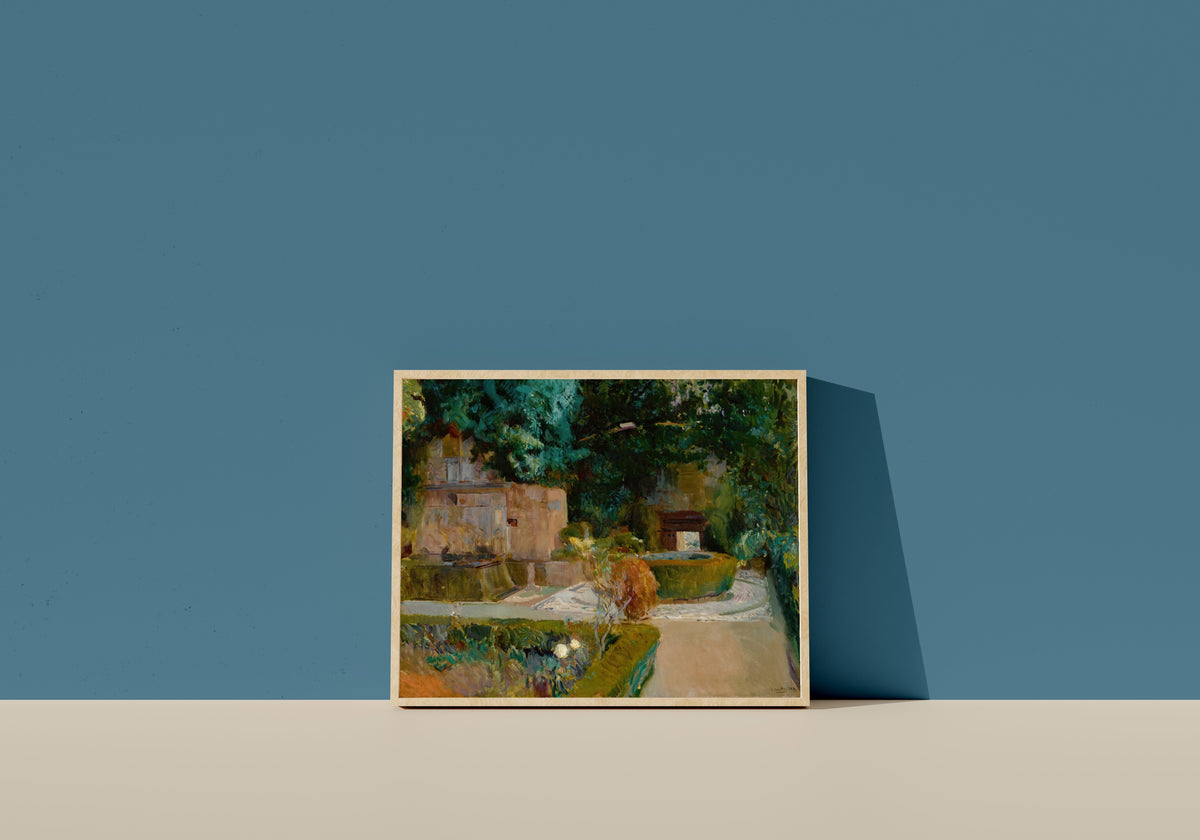 Framed art print of Garden of the Adarves, Alhambra, Granada by Joaquín Sorolla, in a light wood frame leaning on a blue wall
