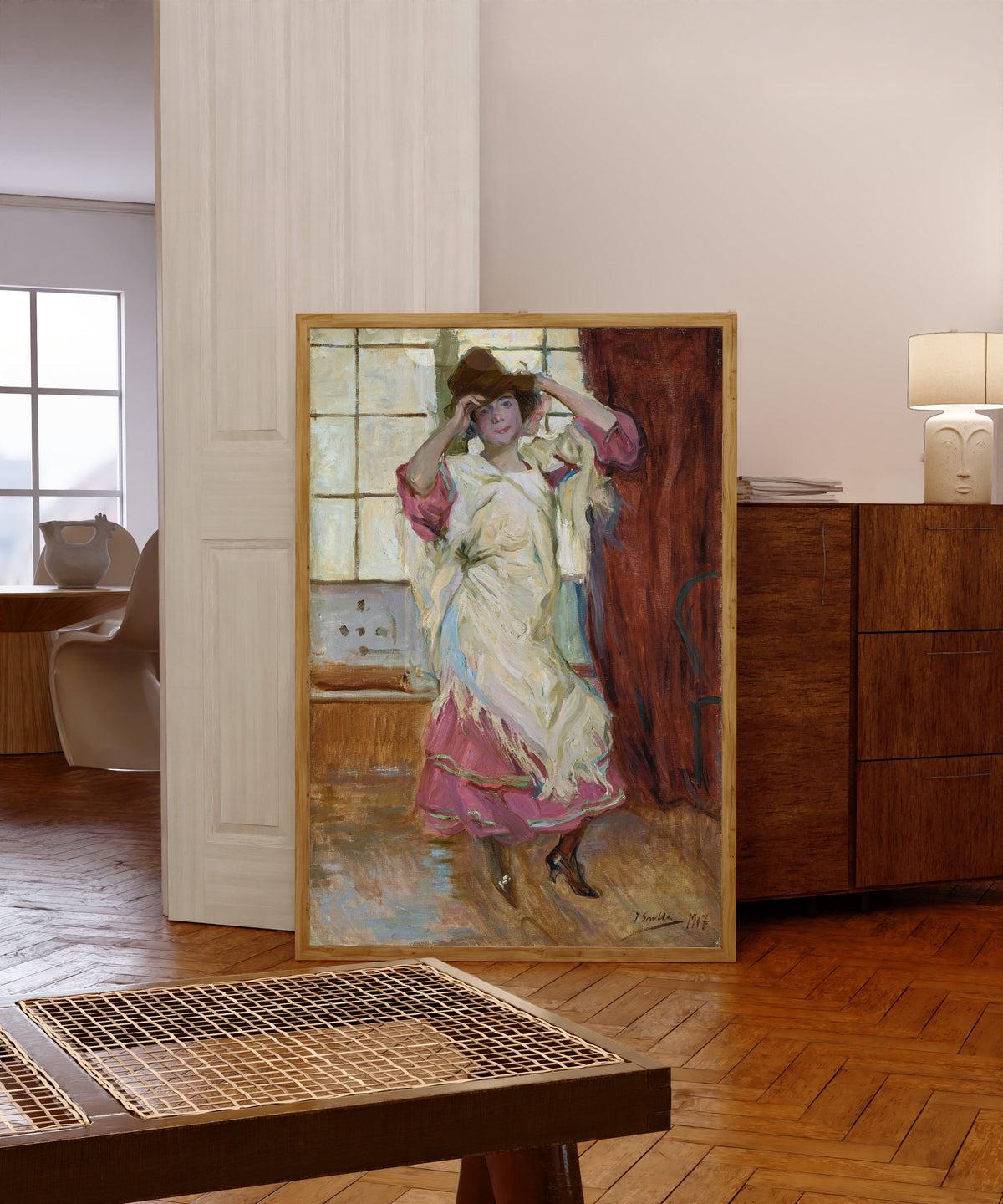 Framed art print of La Bilbainita by Joaquín Sorolla, in a light wood frame leaning in a warm room with a parquet floor