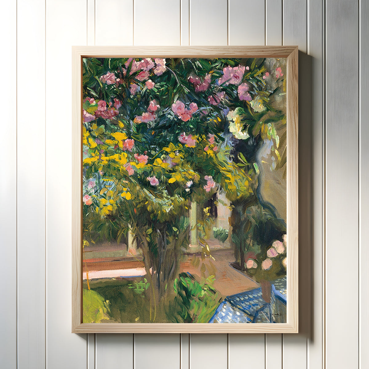Framed art print of Oleanders in the Courtyard of the Artist's House by Joaquín Sorolla, in a light wood frame on a white panelled wall