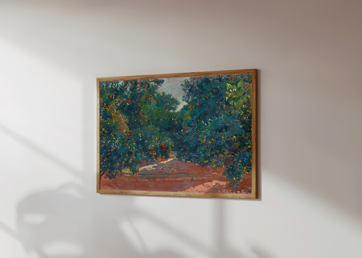 Framed art print of Orange Trees in Alcira by Joaquín Sorolla, in a light wood frame on a sunlit white wall, seen at a slight angle