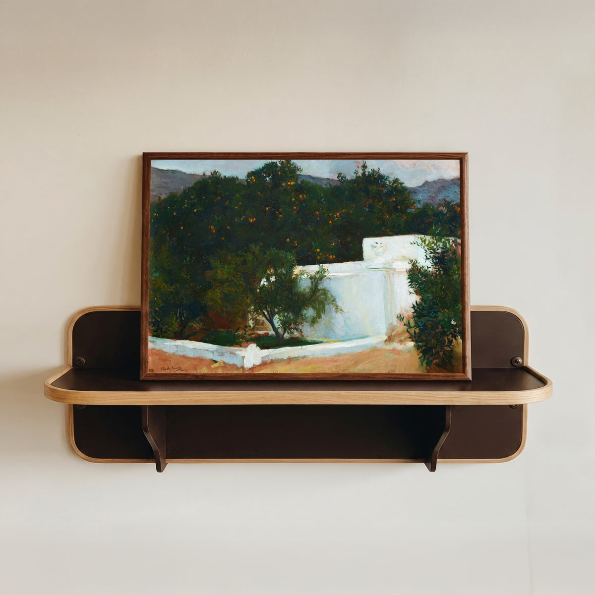 Framed art print of Orange Trees on the Road to the Sea, Valencia by Joaquín Sorolla, in a dark wood frame resting on a wall shelf