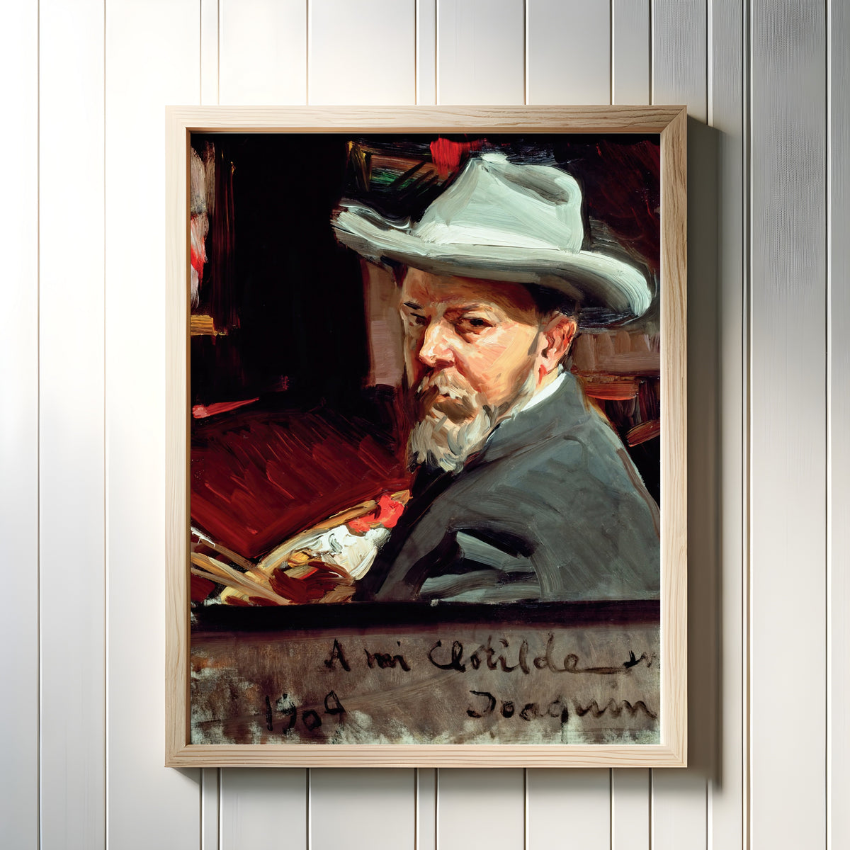Framed art print of Self Portrait by Joaquín Sorolla, in a light wood frame on a white panelled wall