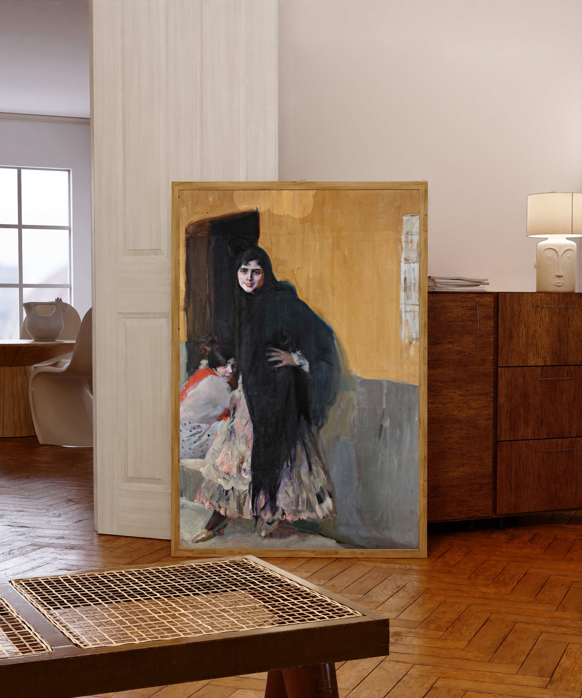 Framed art print of Sevillanas (Ladies of Seville) by Joaquín Sorolla, in a light wood frame leaning in a warm room with a parquet floor
