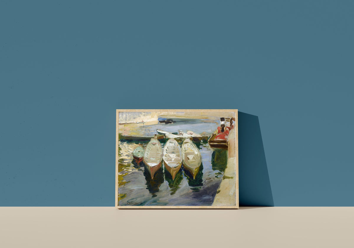 Framed art print of The Basque Port of Guetaria by Joaquín Sorolla, in a light wood frame leaning on a blue wall