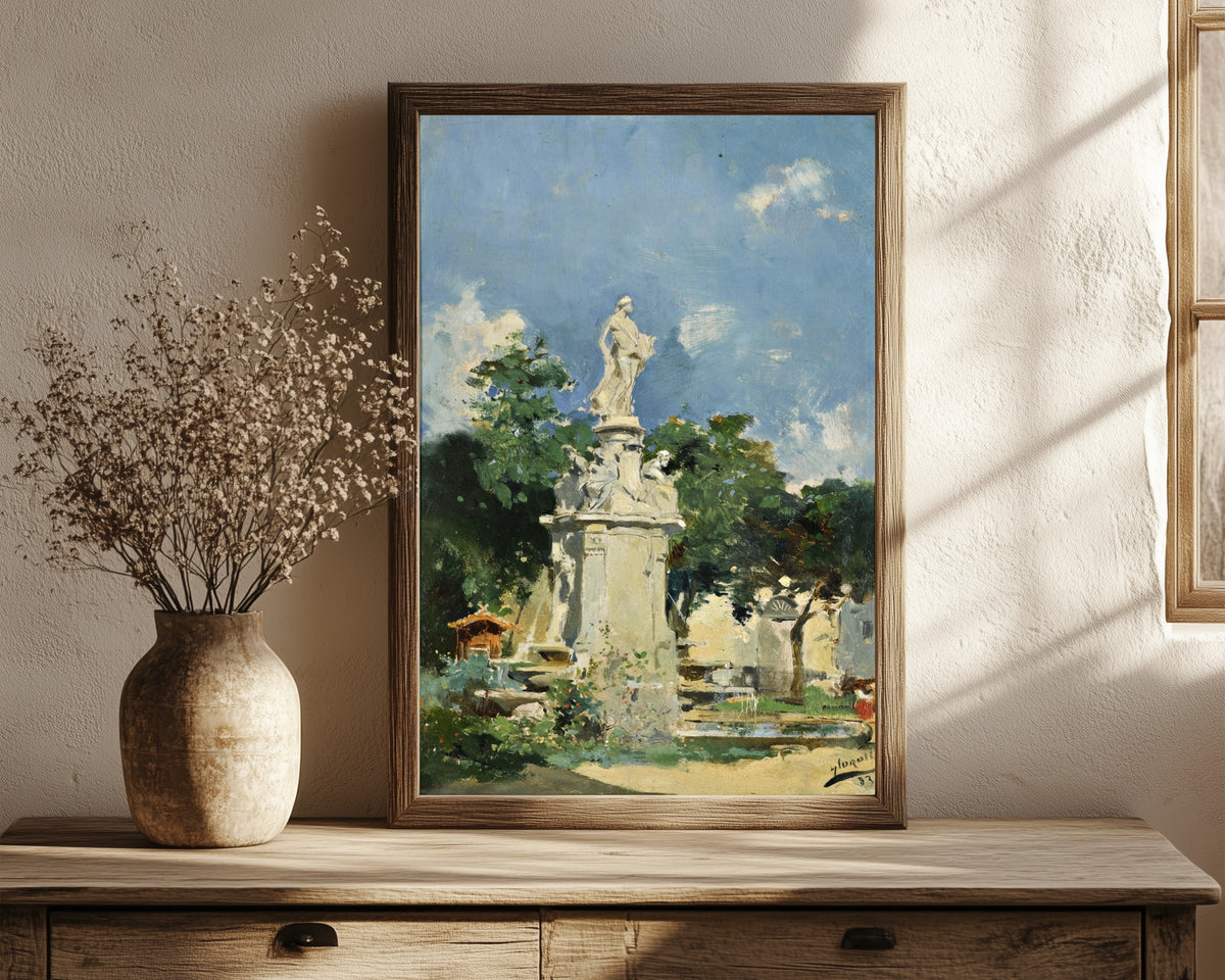 Framed art print of The Fountain of Apollo, Madrid by Joaquín Sorolla, in a dark wood frame leaning on a rustic console beside dried flowers
