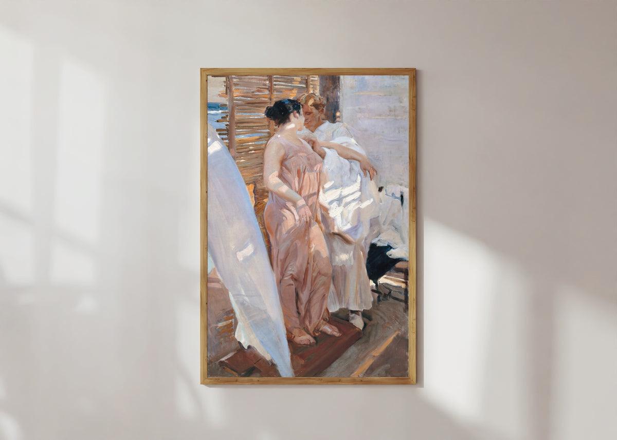 Framed art print of The Pink Robe (After the Bath) by Joaquín Sorolla, in a light wood frame on a sunlit white wall