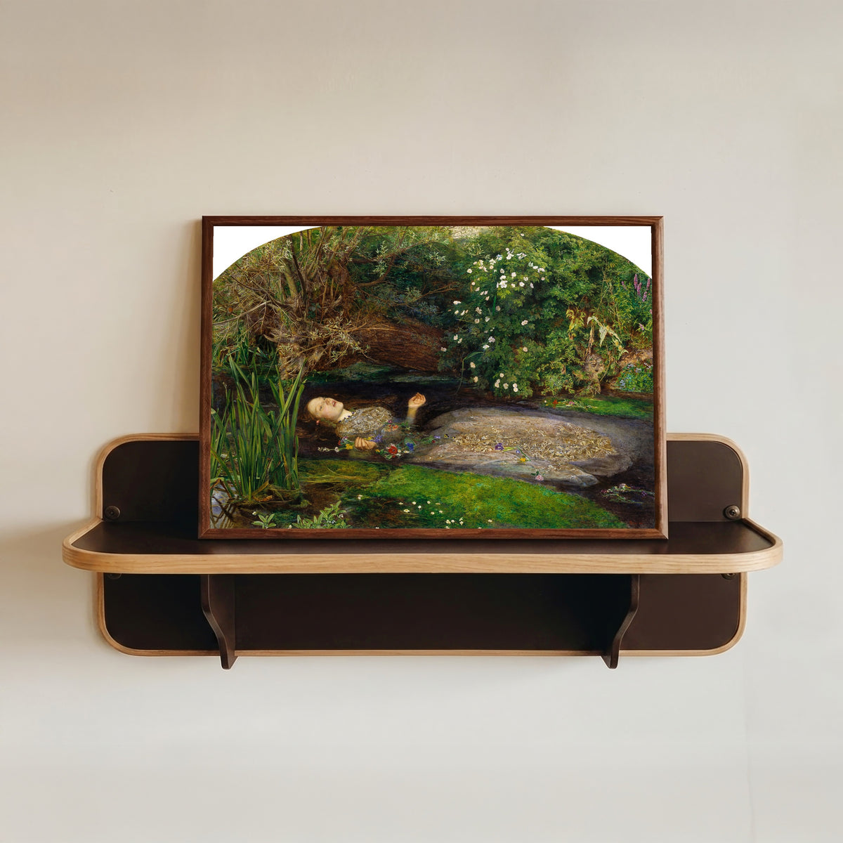 Framed art print of Ophelia by John Everett Millais, in a dark wood frame resting on a wall shelf