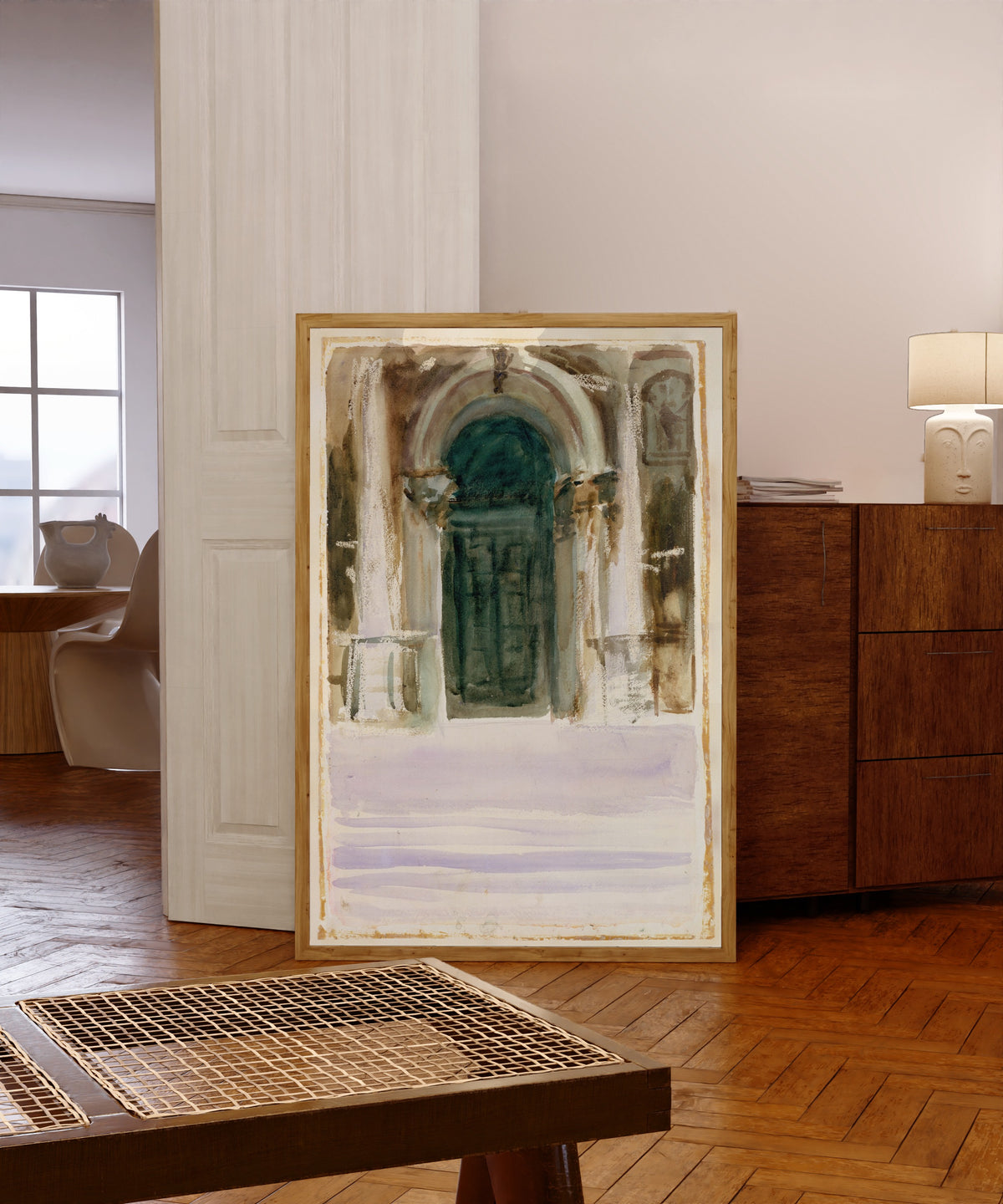 Framed art print of Green Door, Santa Maria della Salute by John Singer Sargent, in a light wood frame leaning in a warm room with a parquet floor
