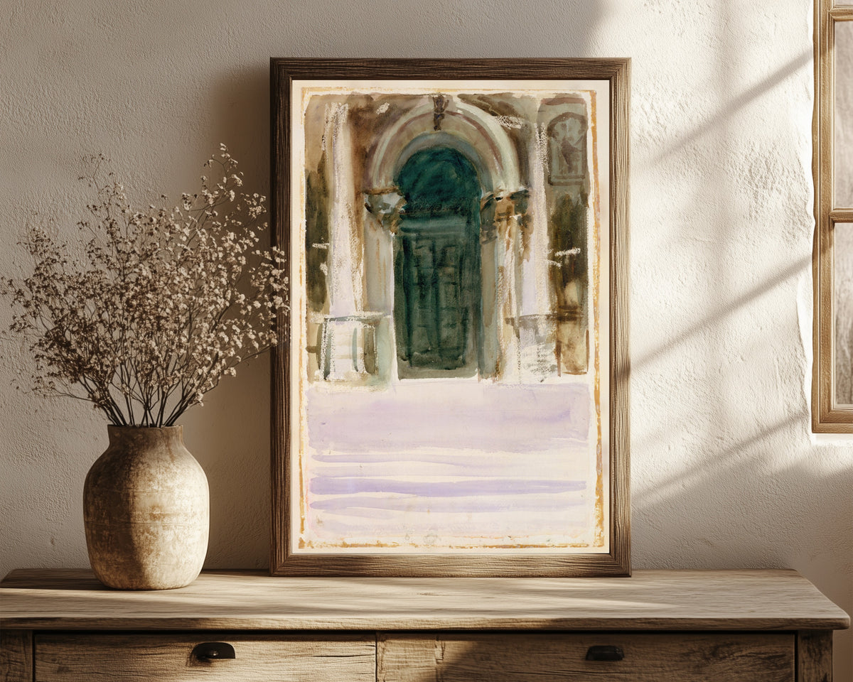 Framed art print of Green Door, Santa Maria della Salute by John Singer Sargent, in a dark wood frame leaning on a rustic console beside dried flowers