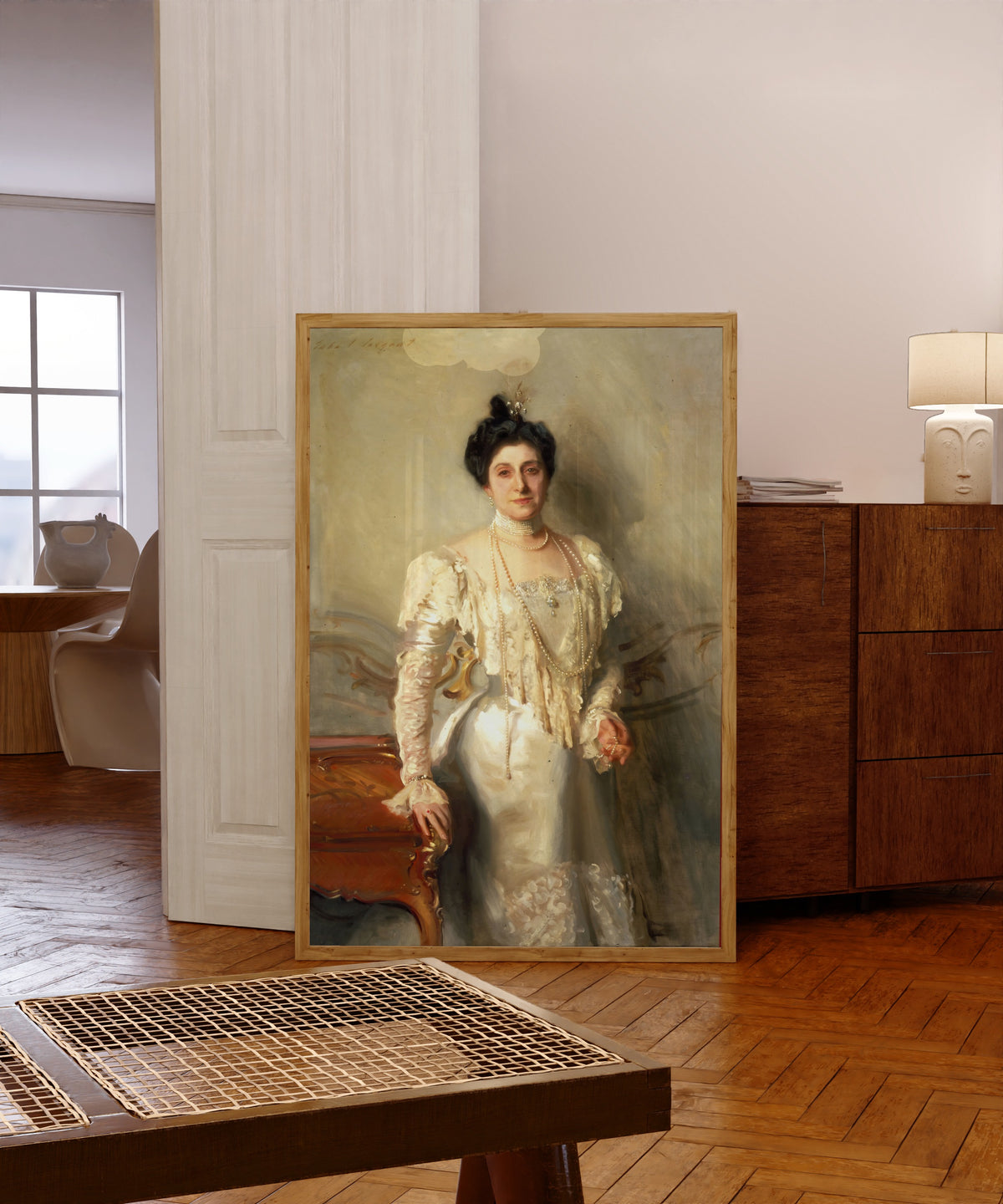Framed art print of Portrait of Mrs. Asher B. Wertheimer by John Singer Sargent, in a light wood frame leaning in a warm room with a parquet floor
