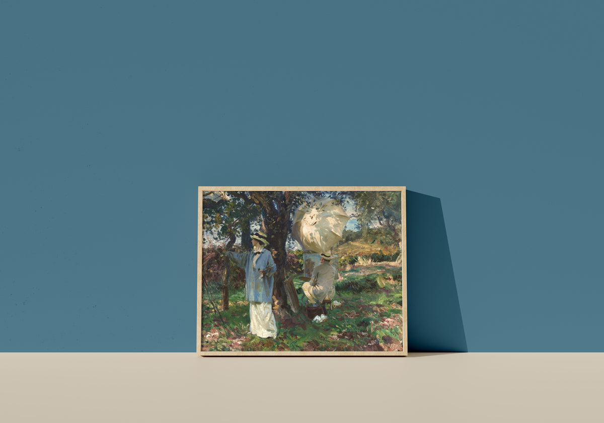 Framed art print of The Sketchers by John Singer Sargent, in a light wood frame leaning on a blue wall